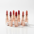 Luxury lipstick collection in rose gold and white packaging showing multiple shades